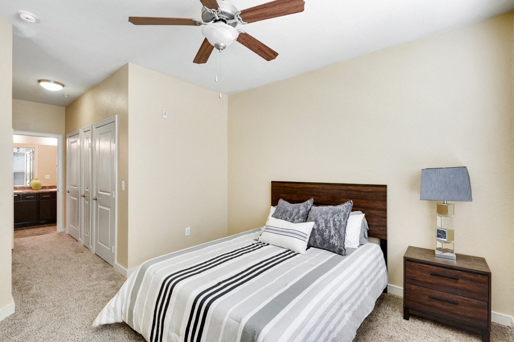 the master bedroom has a large bed and a ceiling fan