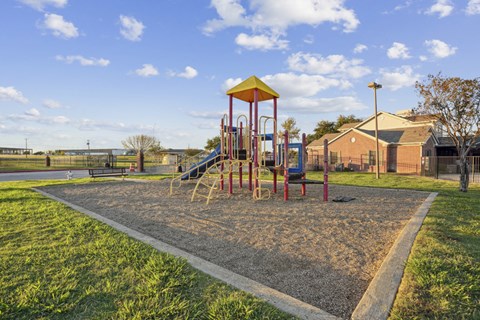 A playground with a yellow and red slide and a yellow and red structure.