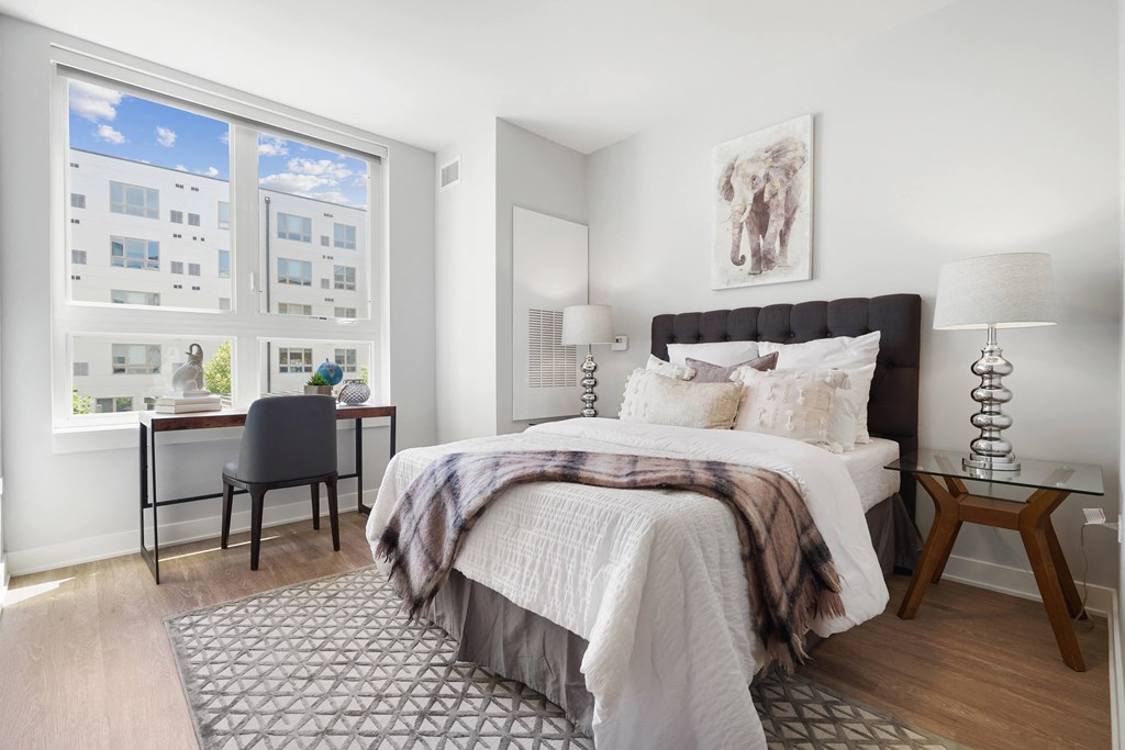 a bedroom with a large bed and two windows