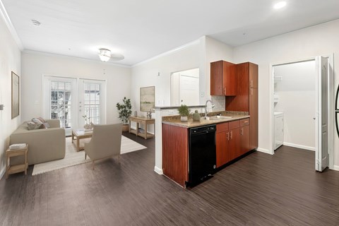 A modern kitchen with wooden cabinets and a black dishwasher.