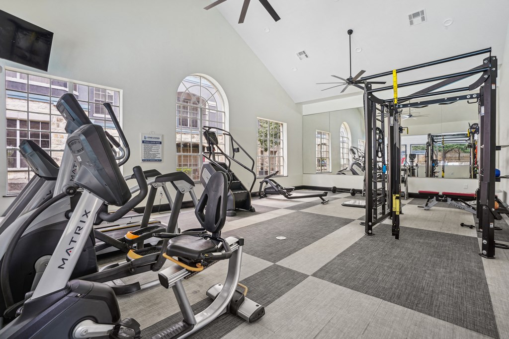 A gym with a variety of equipment including a stationary bike and a pull up bar.