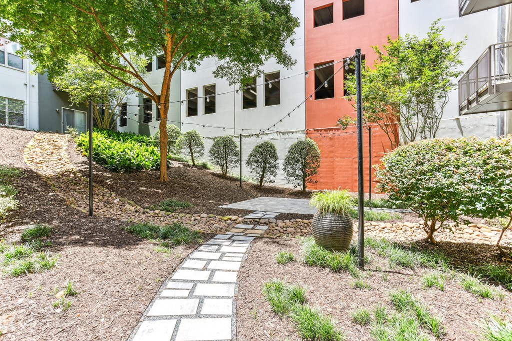 A garden with a stone pathway leading to a building.