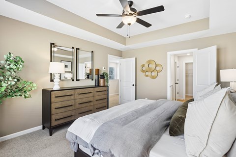 A bedroom with a large bed and a ceiling fan.