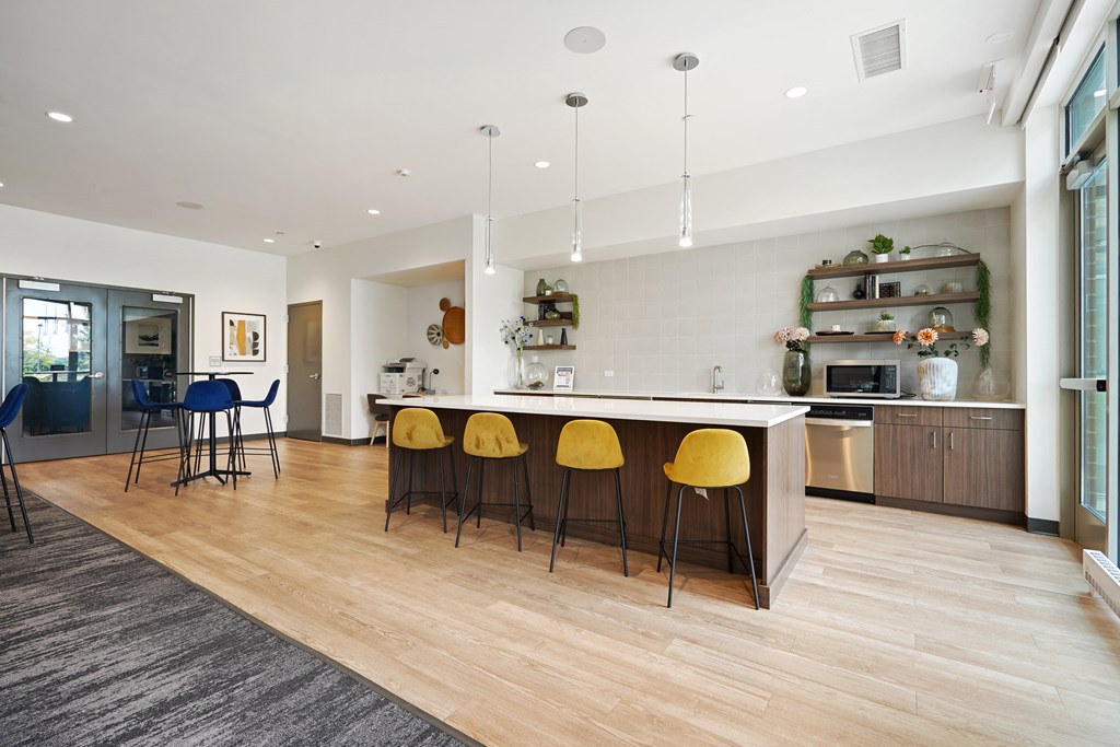 a kitchen and living room with white walls and hardwood flooring