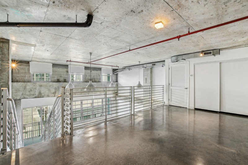 a large room with a railing and a staircase in a building