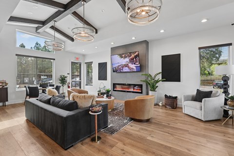 A modern living room with a black sofa and a wooden floor.