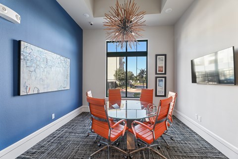 A dining room with a table and chairs.