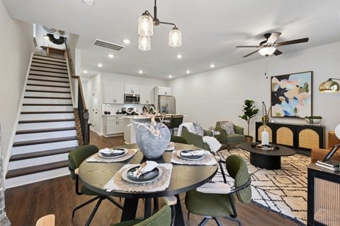 A modern dining room with a round table set for two.