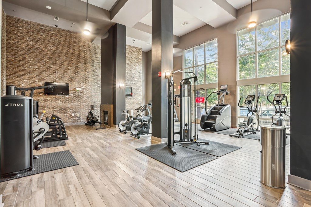 A gym with a brick wall and wooden floors.