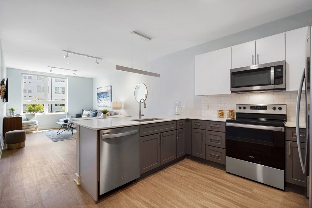 a large kitchen with stainless steel appliances and a wooden floor