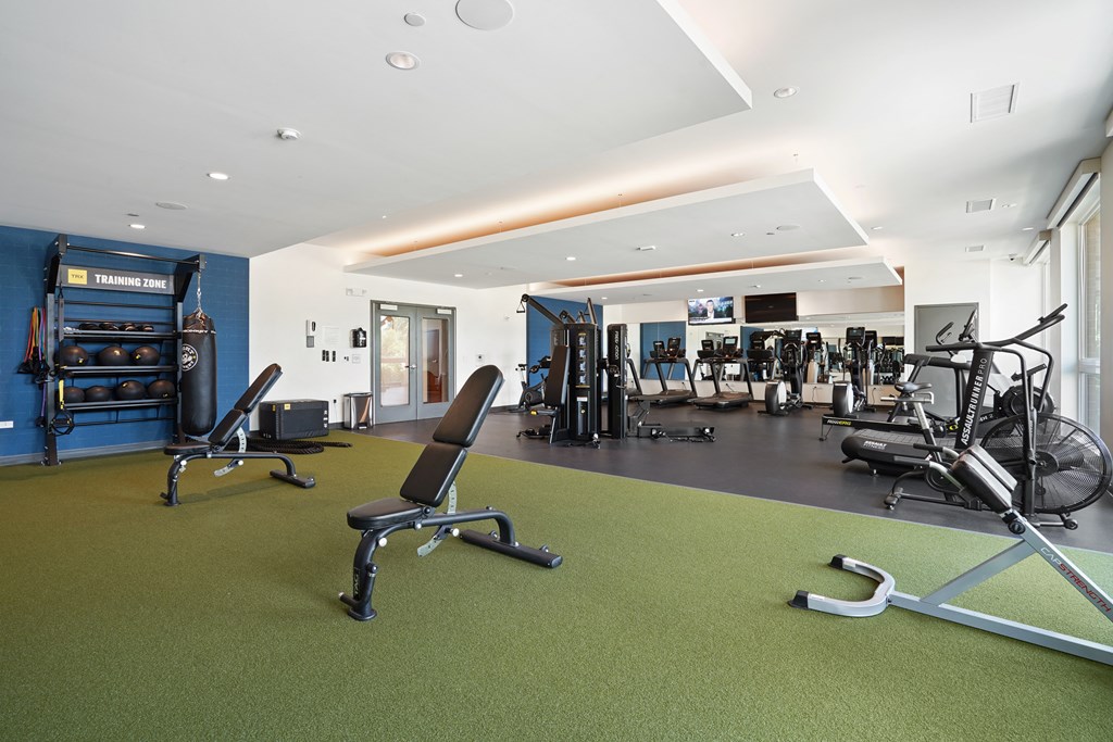 a gym with green carpet and exercise equipment