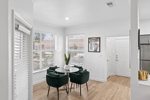 A dining room with a table and chairs.