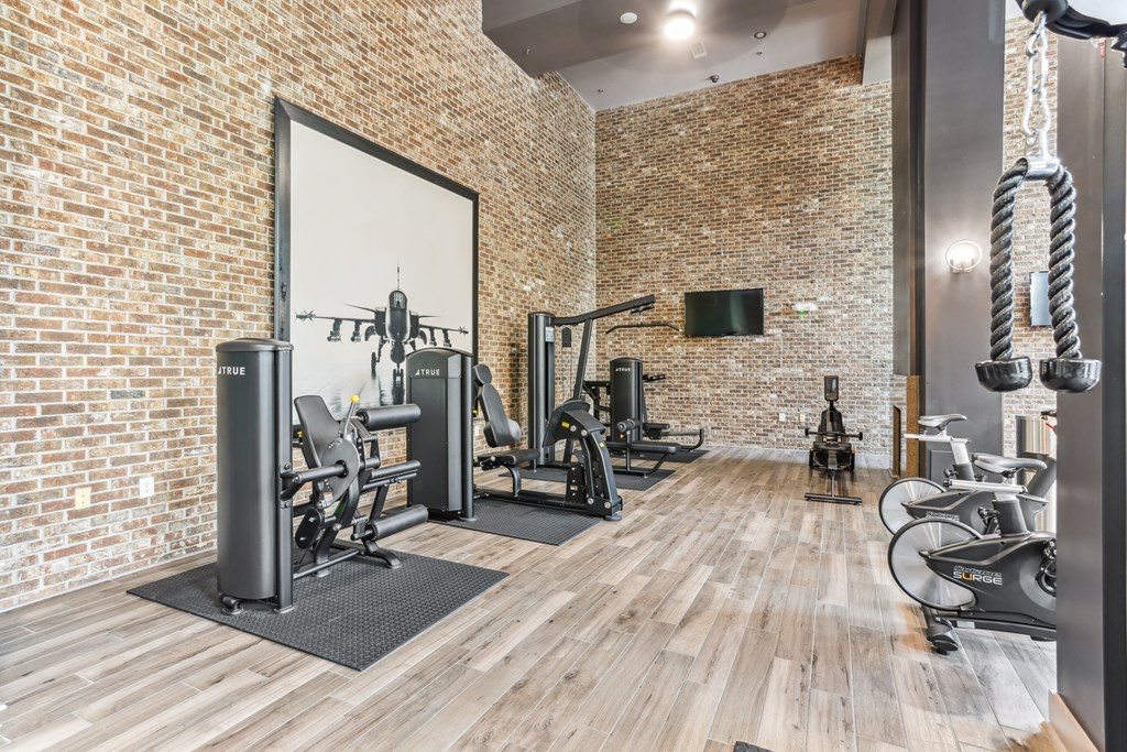 A gym with a brick wall and wooden floors.