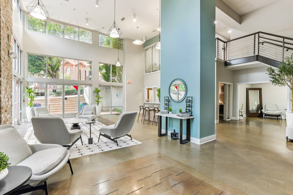 A spacious waiting area with grey chairs and a wooden floor.