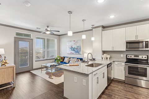 A modern kitchen with a large island and stainless steel appliances.