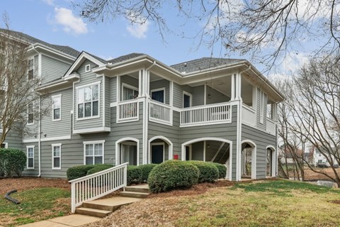 A grey two-story house with a white porch.