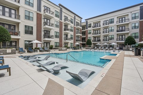 A large swimming pool in front of apartment buildings.