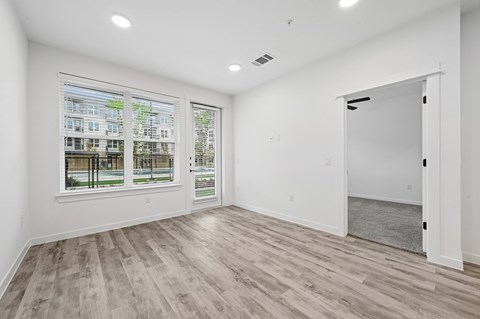 A room with a large window and a view of a building across the street.