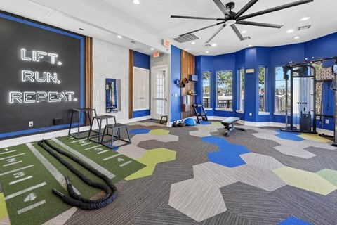A gym with a treadmill, weights, and a mirror.