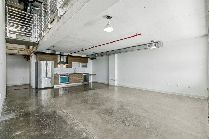 the interior of an empty warehouse with a kitchen and a staircase on the wall