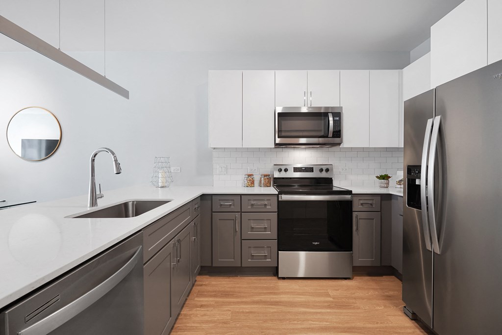a kitchen with white countertops and gray cabinets