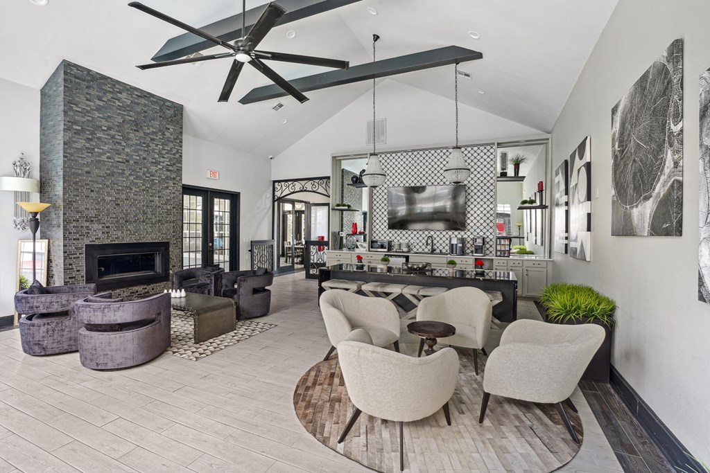 A modern living room with a stone fireplace and a large fan.