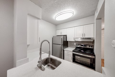 A kitchen with a stainless steel refrigerator, oven, and microwave.