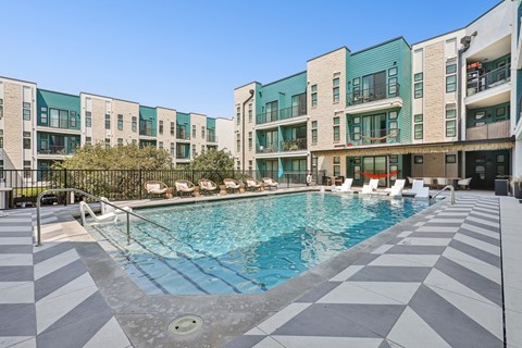 A swimming pool in front of a building with a black and white checkered floor.