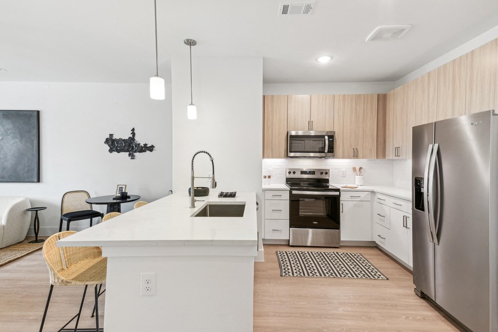 A modern kitchen with a white island and stainless steel appliances.