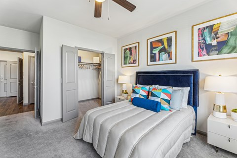 A bedroom with a large bed and a ceiling fan.