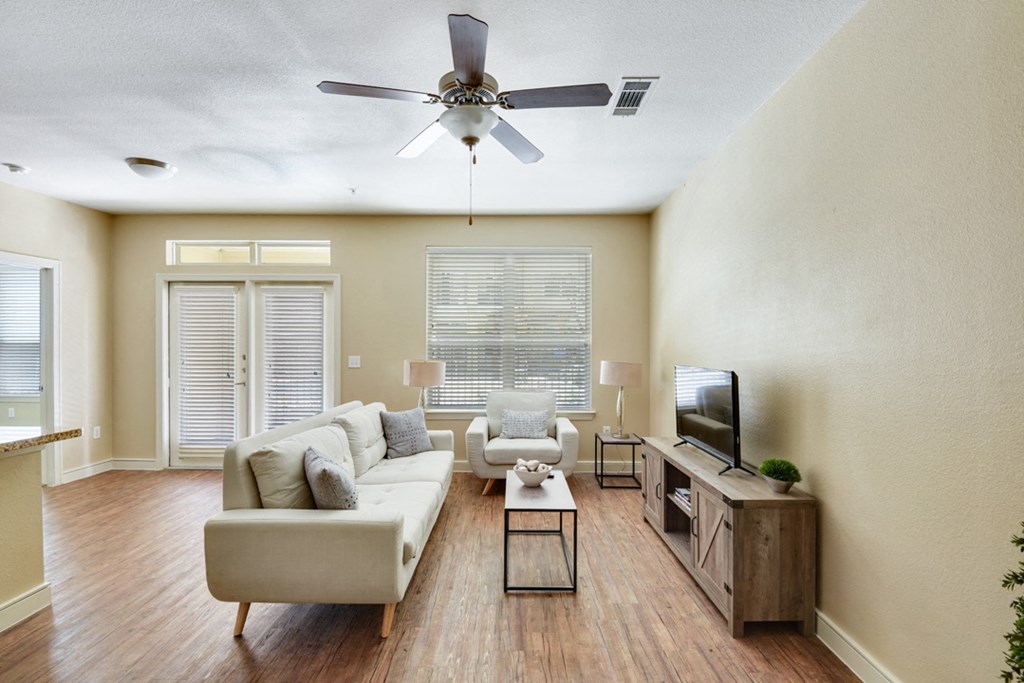 a living room with a couch and a ceiling fan