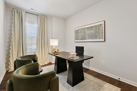 A living room with a black table and green chairs.
