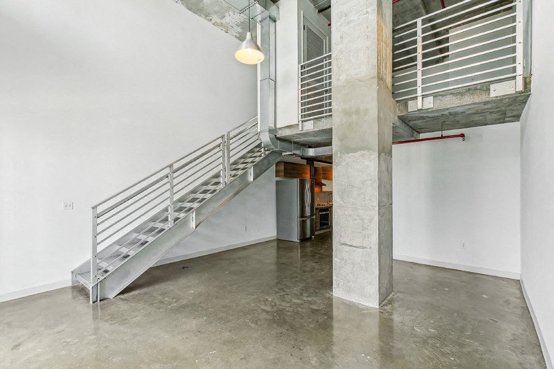 the interior of a building with a staircase and a concrete floor