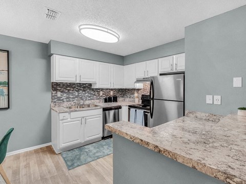 a kitchen with white cabinets and stainless steel appliances