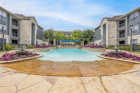 a large swimming pool with an apartment building in the background