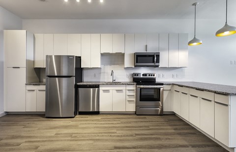 A modern kitchen with a stainless steel refrigerator and oven.