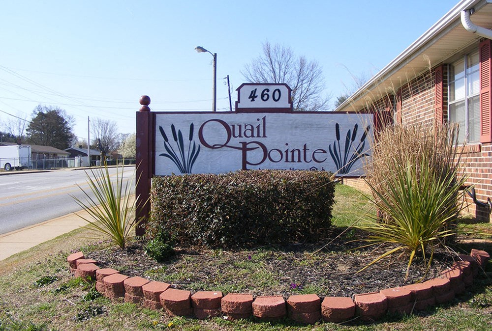 a sign in front of a building that says quail pointe