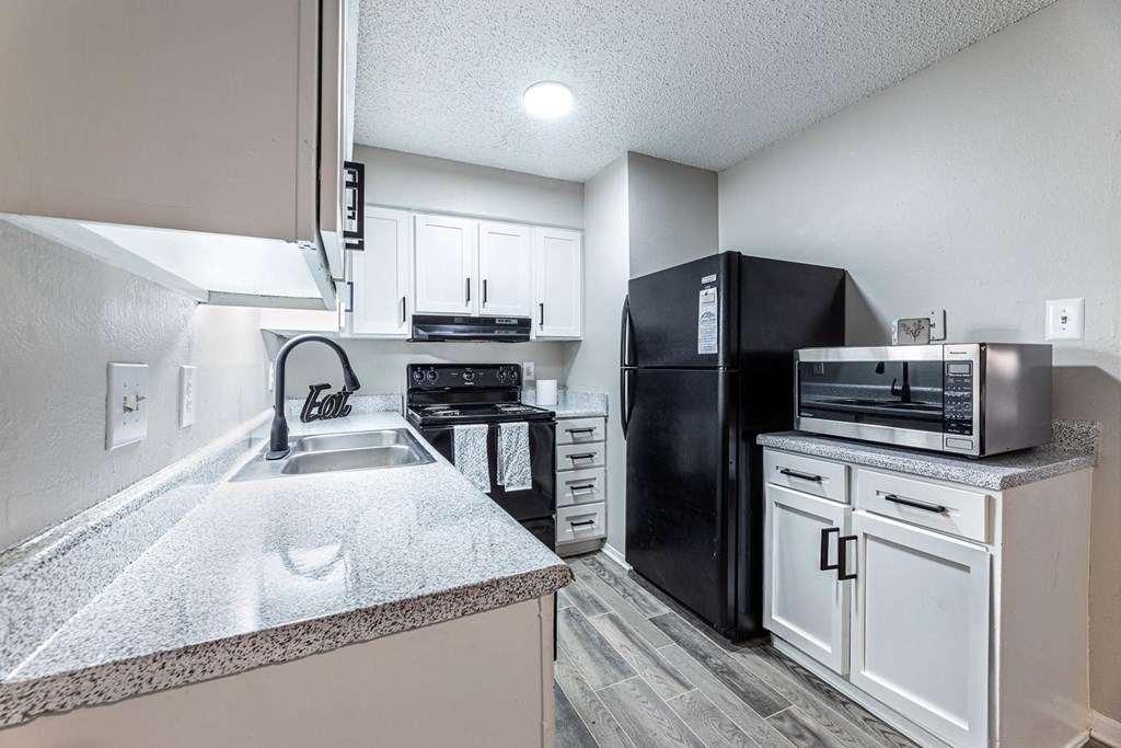 a kitchen with black appliances and white cabinets