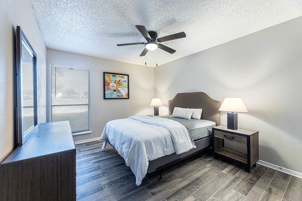 a bedroom with a bed and a ceiling fan