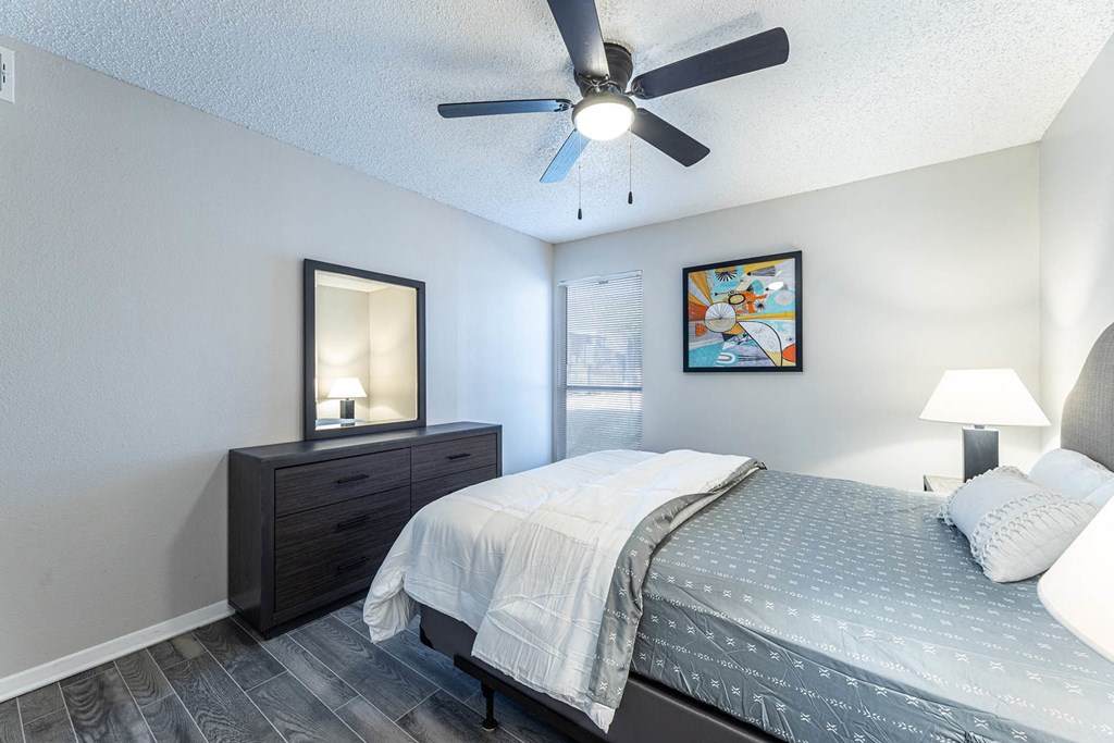 a bedroom with a bed and a ceiling fan