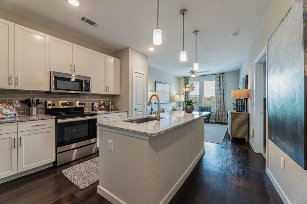 a kitchen with white cabinets and a large island with granite countertops