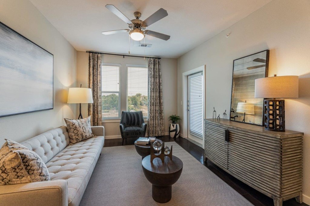 a living room with a ceiling fan and a large window