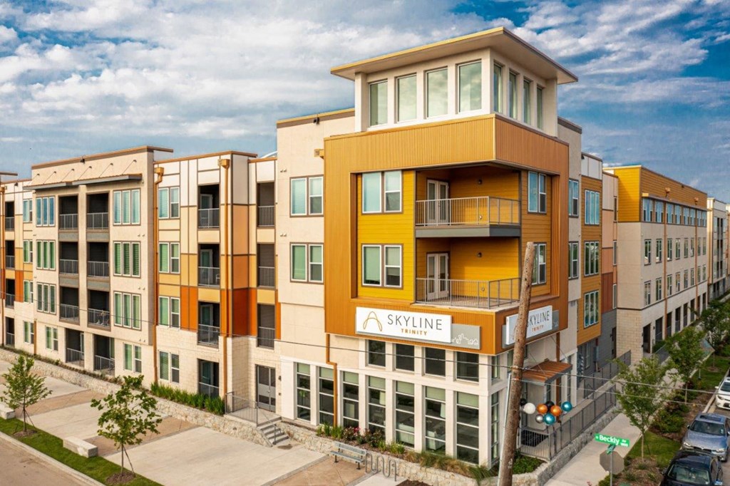 a building with a yellow and orange facade and a blue sky in the background