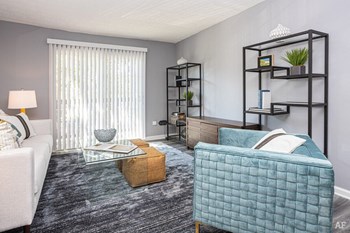 Living area with modern furniture and sliding glass doors. - Photo Gallery 2