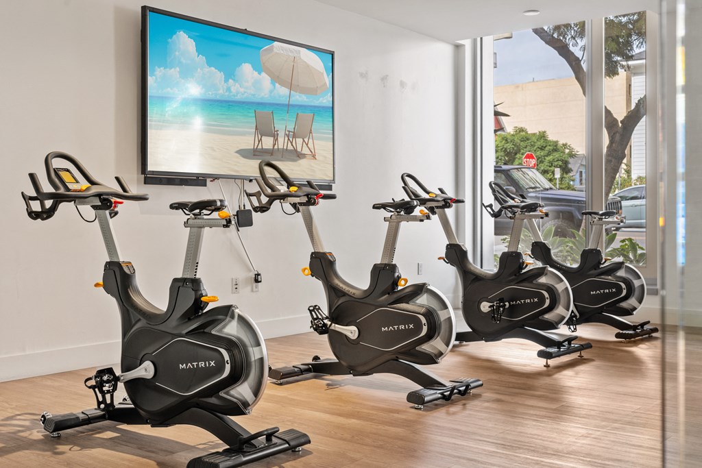 a gym with exercise bikes in front of a window