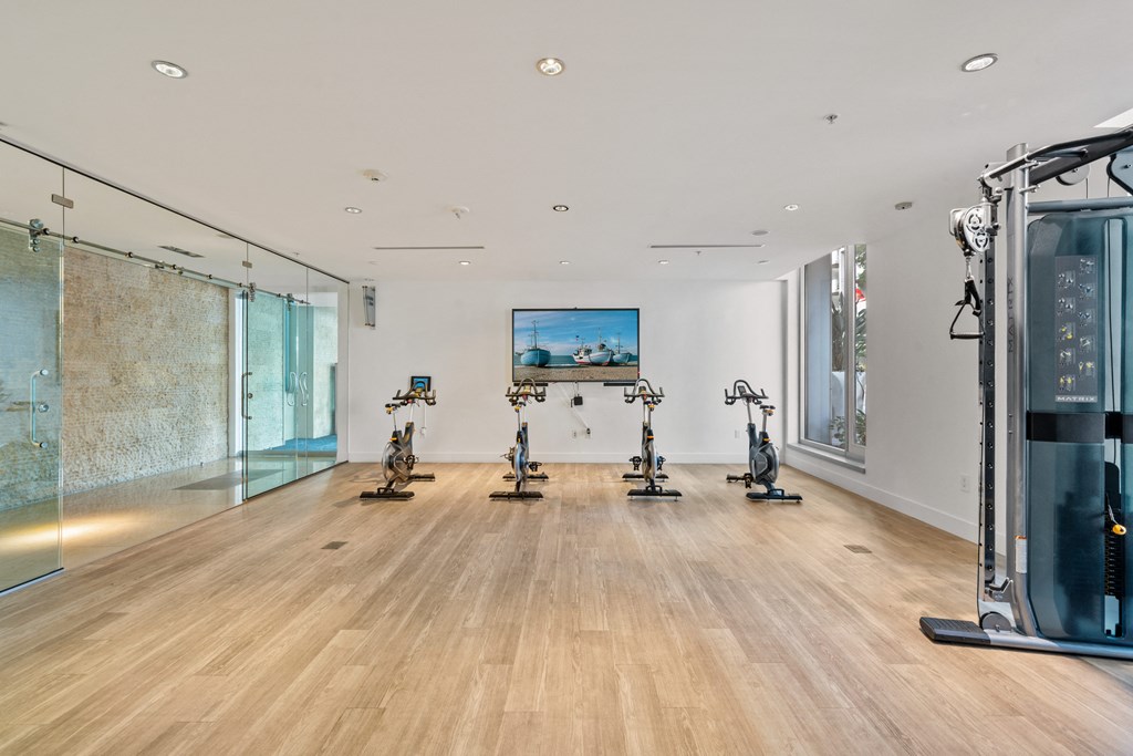 a large room with exercise machines and a painting on the wall