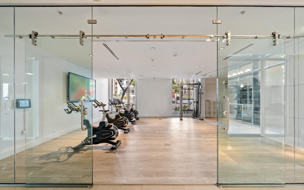 a gym with glass doors and a painting on the wall