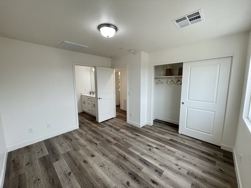 an empty living room with white walls and wood flooring