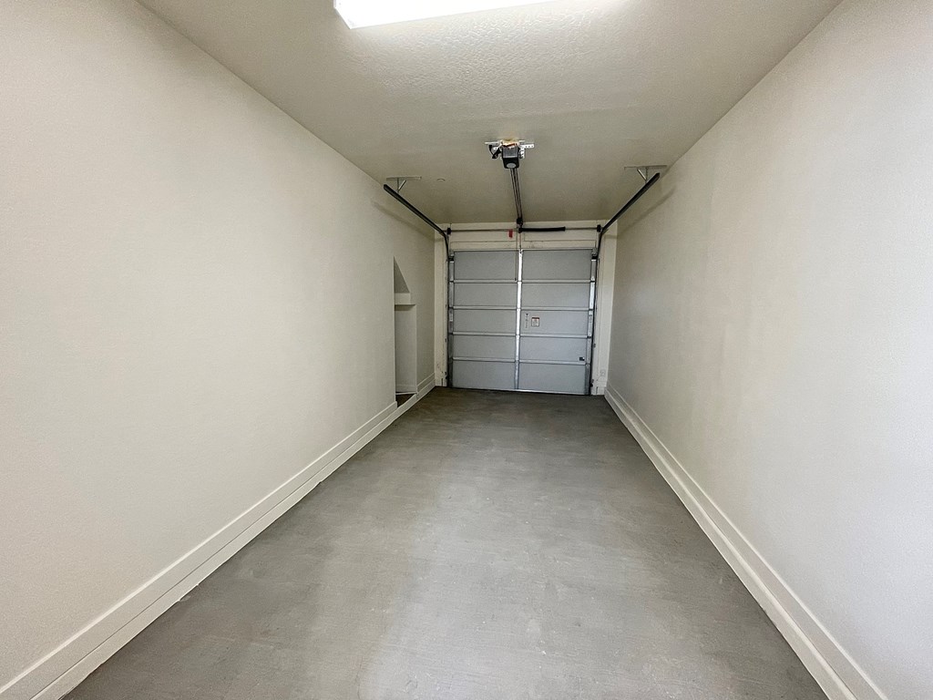 a large empty room with white walls and a gray floor