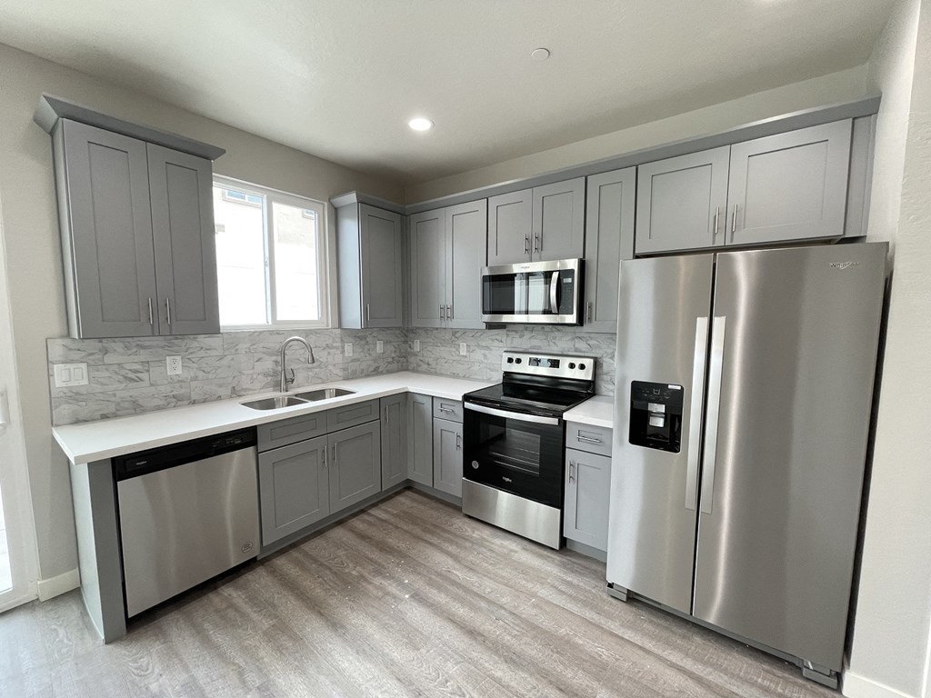 a kitchen with stainless steel appliances and gray cabinets